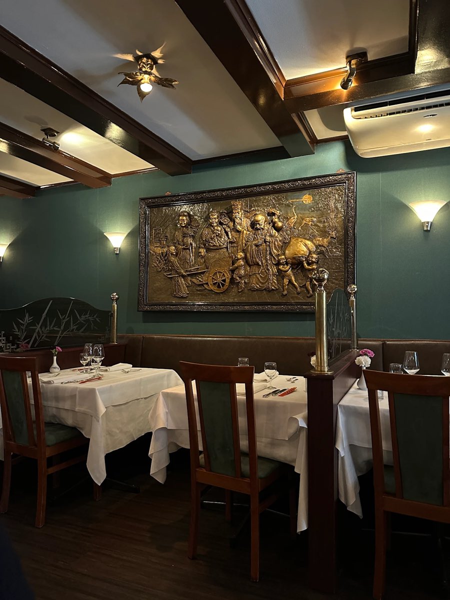 Eetzaal met bronzen reliëf en wit gedekte tafels